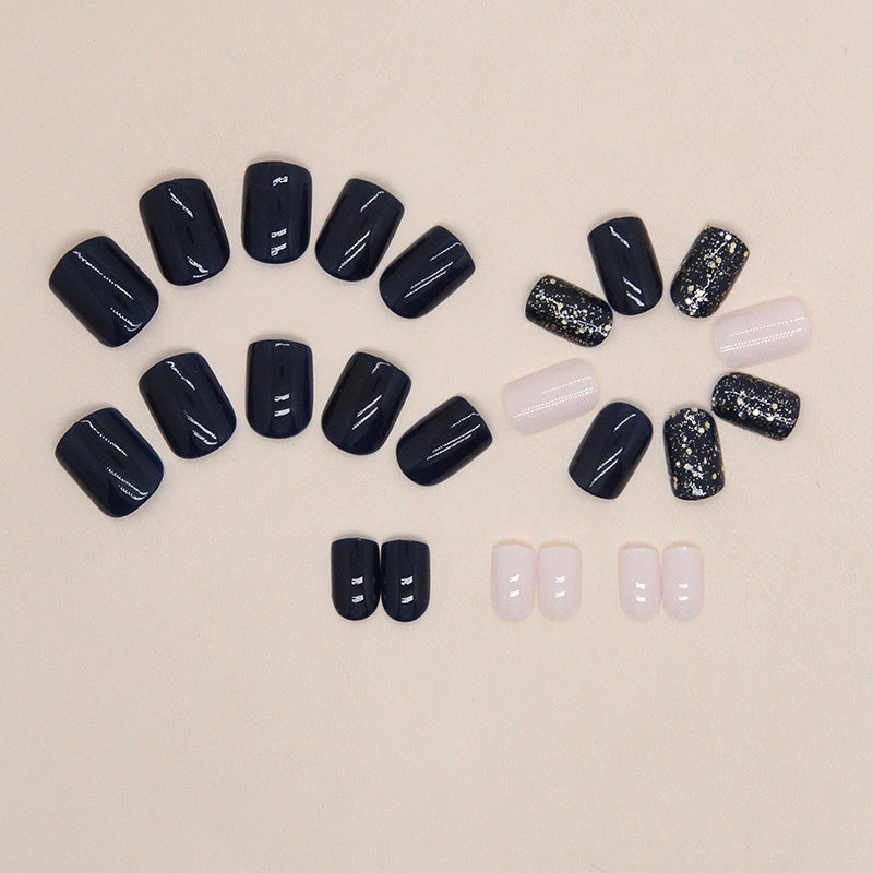 Uñas postizas cortas con purpurina y estrellas en color azul oscuro