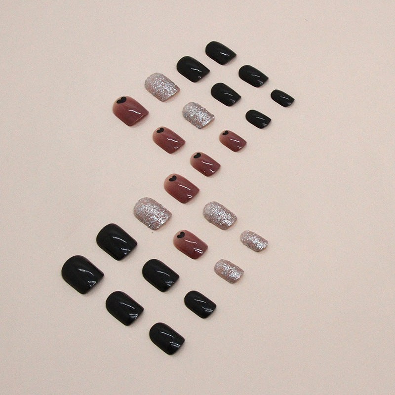 Uñas cortas con corazón negro y purpurina