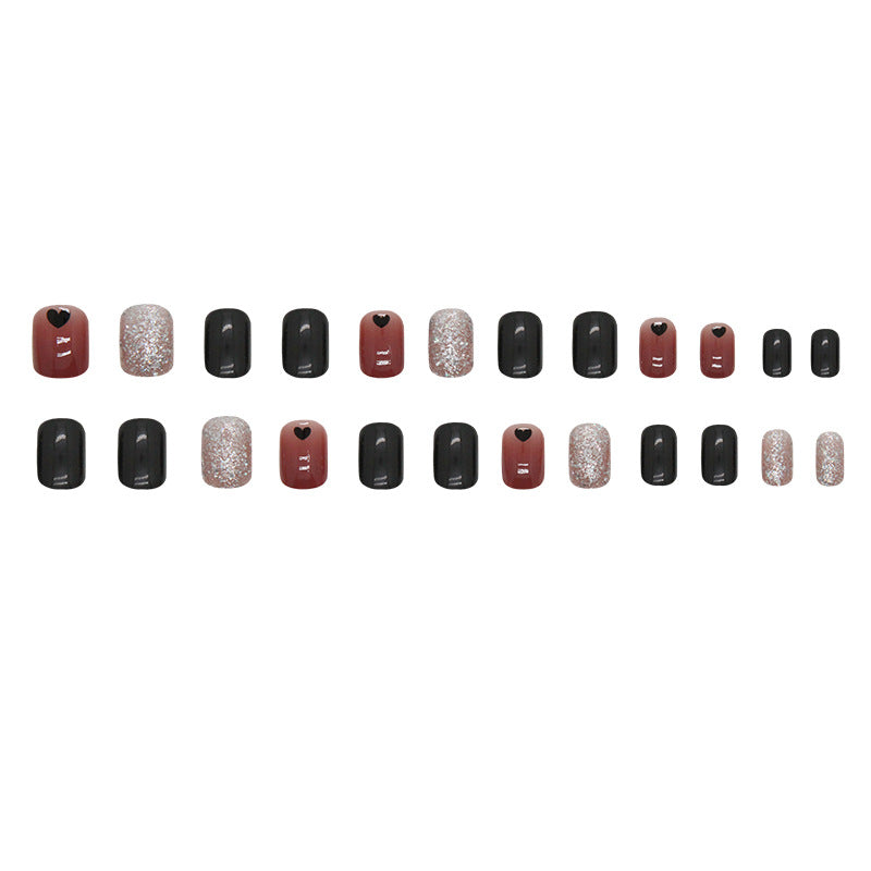 Uñas cortas con corazón negro y purpurina