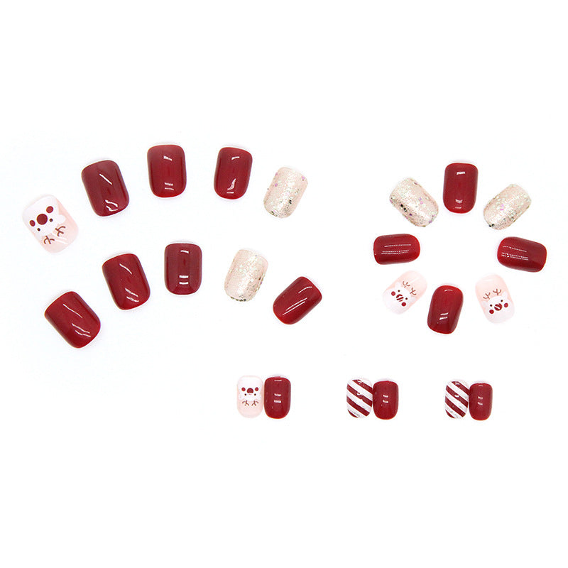 Uñas navideñas con renos en color rojo granada