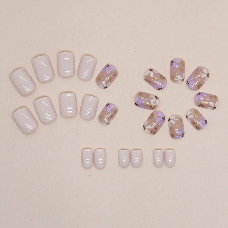 Uñas postizas cortas con purpurina y diseño floral en amarillo y morado