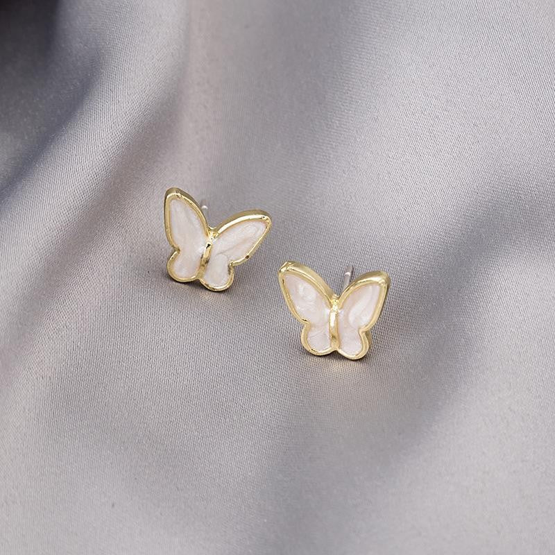 Pendientes de botón con alas de mariposa que gotean aceite blanco