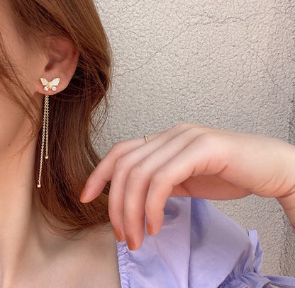 Un par de pendientes largos con forma de mariposa. 