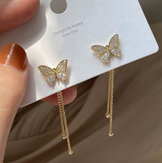 Un par de pendientes largos con forma de mariposa. 