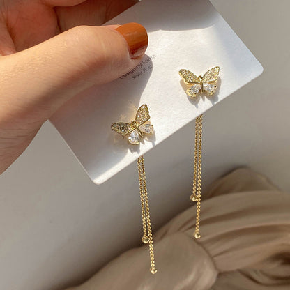 Un par de pendientes largos con forma de mariposa. 