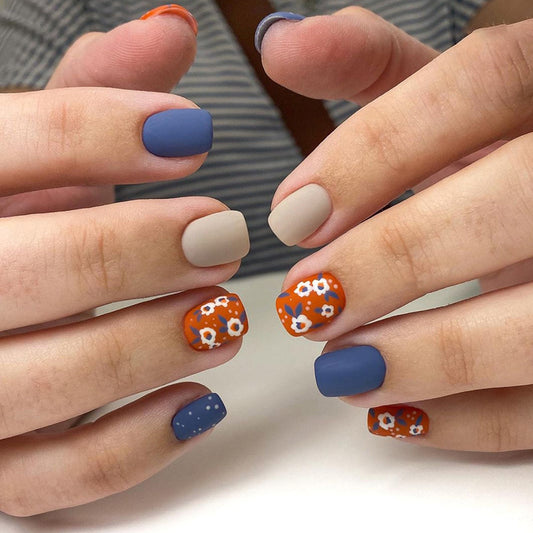 Uñas postizas cuadradas con diseño floral en tonos marrones y azules 
