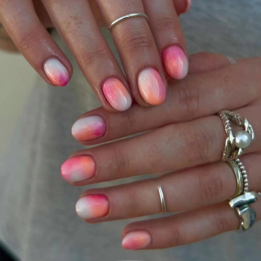 Uñas postizas cortas redondas con degradado de color naranja y rosa 