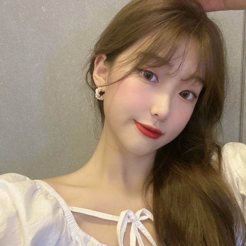 C-shaped earrings, pearl earrings.