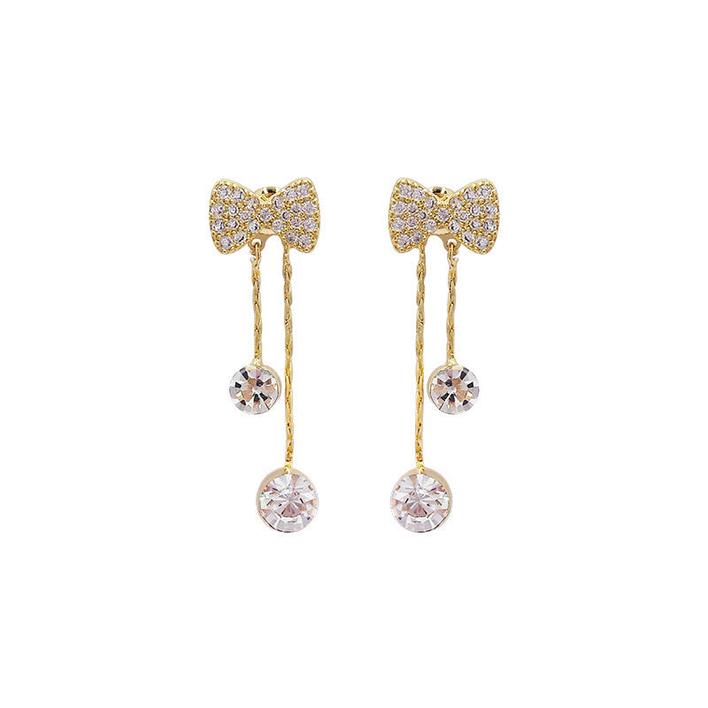 Un par de pendientes con forma de lazo y pendientes colgantes con diamantes brillantes. 
