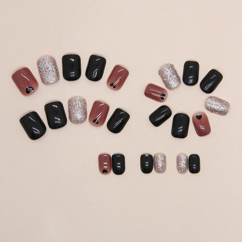 Uñas cortas con corazón negro y purpurina 