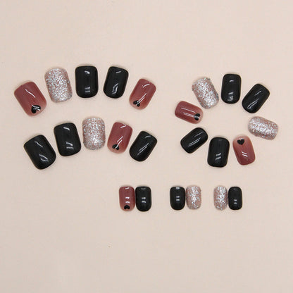 Uñas cortas con corazón negro y purpurina 