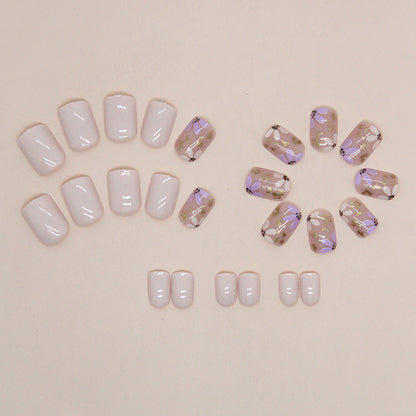 Uñas postizas cortas con purpurina y diseño floral en amarillo y morado 