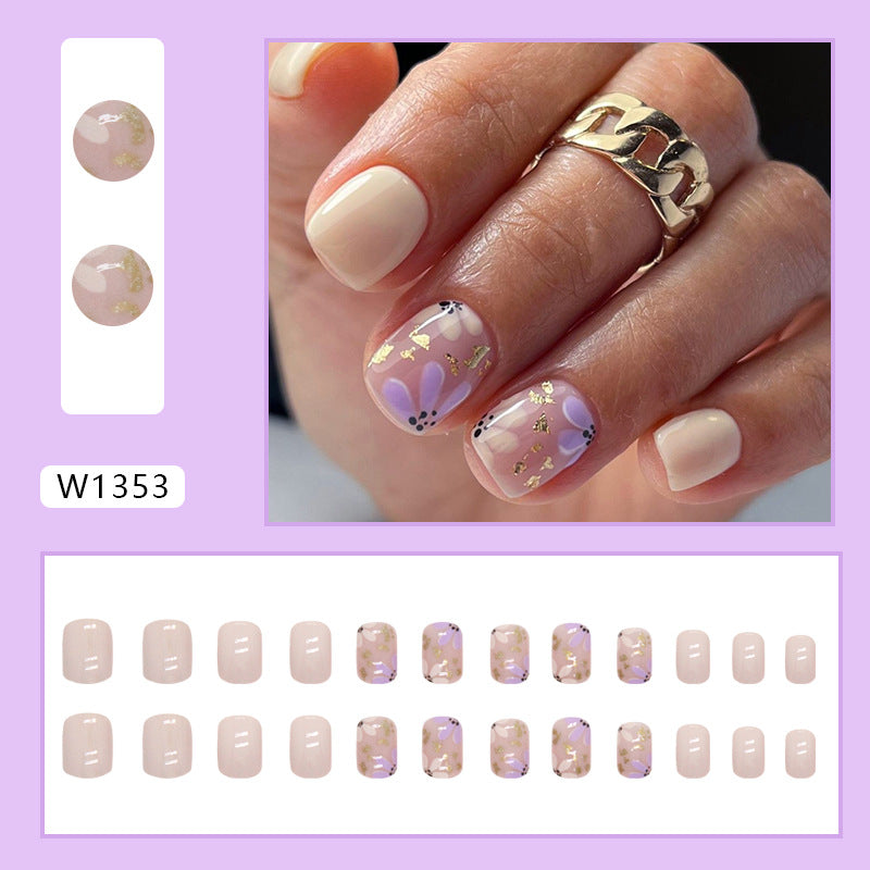 Uñas postizas cortas con purpurina y diseño floral en amarillo y morado 