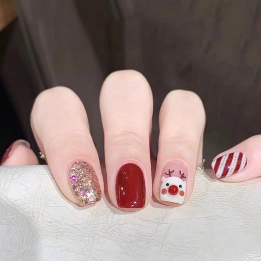 Uñas navideñas con renos en color rojo granada 